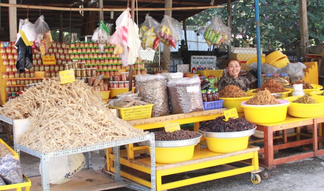 Gian hàng đặc sản chao môn, mủ trôm, mủ gòn, lười ươi dưới chân núi Cậu (Ảnh: XUÂN THI)