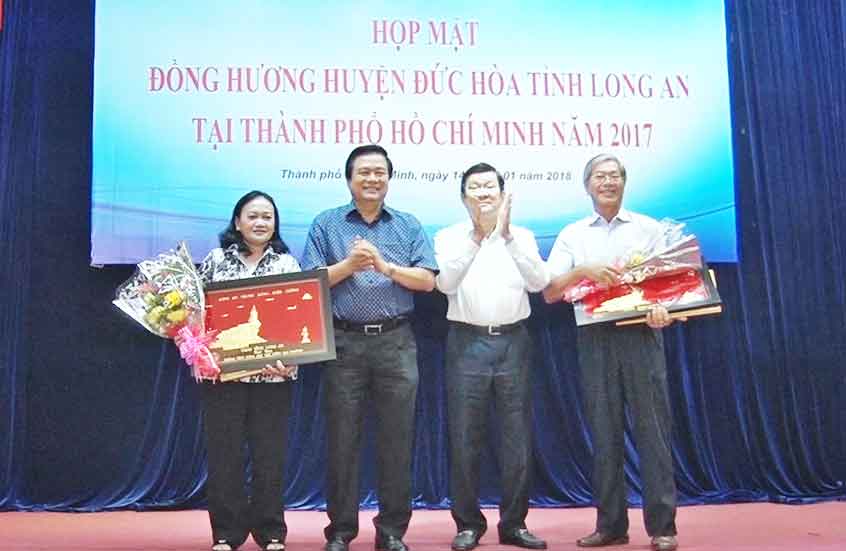 Former president Truong Tan Sang and Long An Party Committee Secretary Pham Van Ranh give certificates of merit to teams and individuals for their contributions to welfare in Duc Hoa district  