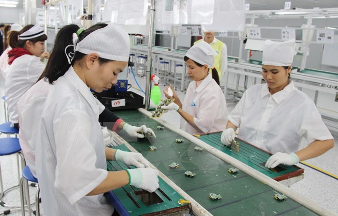 Workers at a foreign-invested firm manufacturing mobile phone spare parts in Vietnam (Photo: VNA)