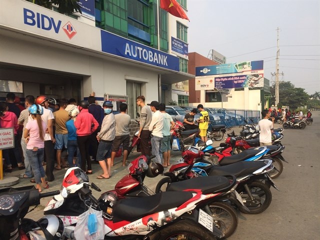 Workers at industrial parks in the southern province of Binh Duong queue up at BIDV's ATMs to withdraw cash.(Photo: VNA)