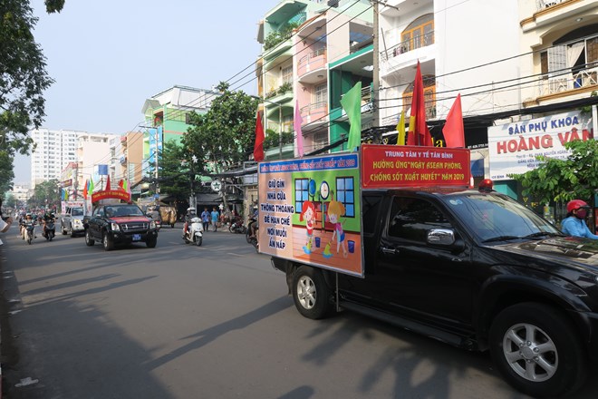 Cars bearing anti-dengue fever ads parade HCM City streets as part of the launch (Photo: VNA)