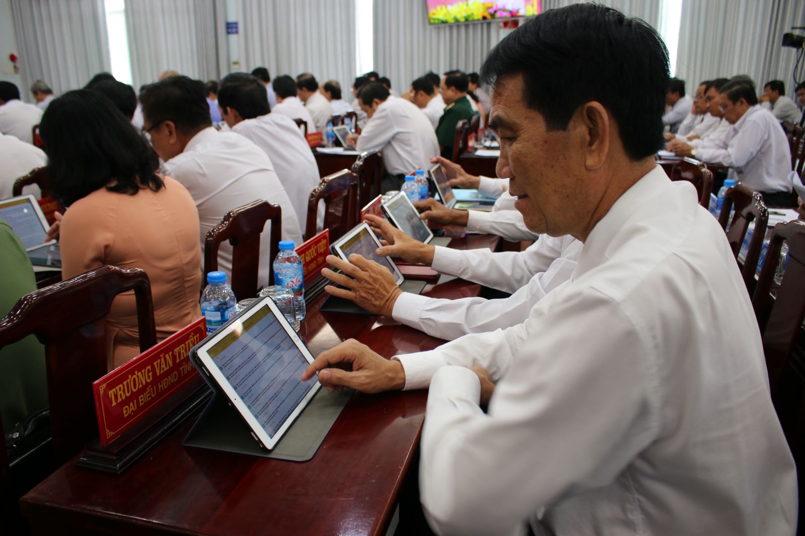 Delegates look up documents on tablets