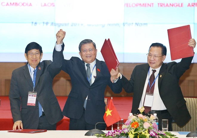 From left: Head of the Lao National Assembly's external relations committee Eksavang Vongvichit; head of the Vietnamese National Assembly's external relations committee Nguyen Van Giau; and head of the committee for external relations, international cooperation, information and communications of the Cambodian parliament Chheang Vun celebrate after the joint statement was signed (Photo: VNA)