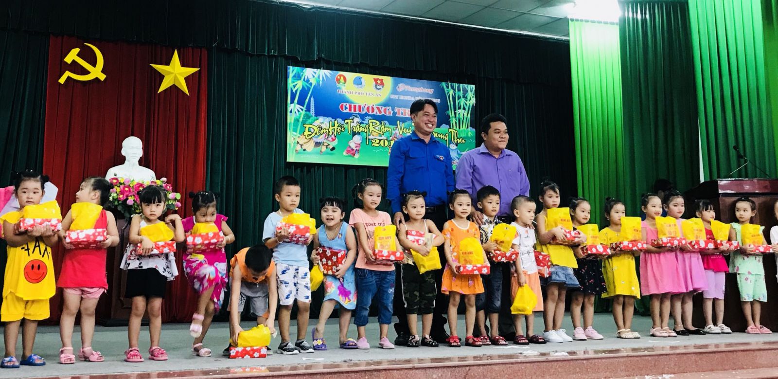 Secretary of Tan An City Youth Union - Ha Ngoc Diep (green shirt) presents gifts to children