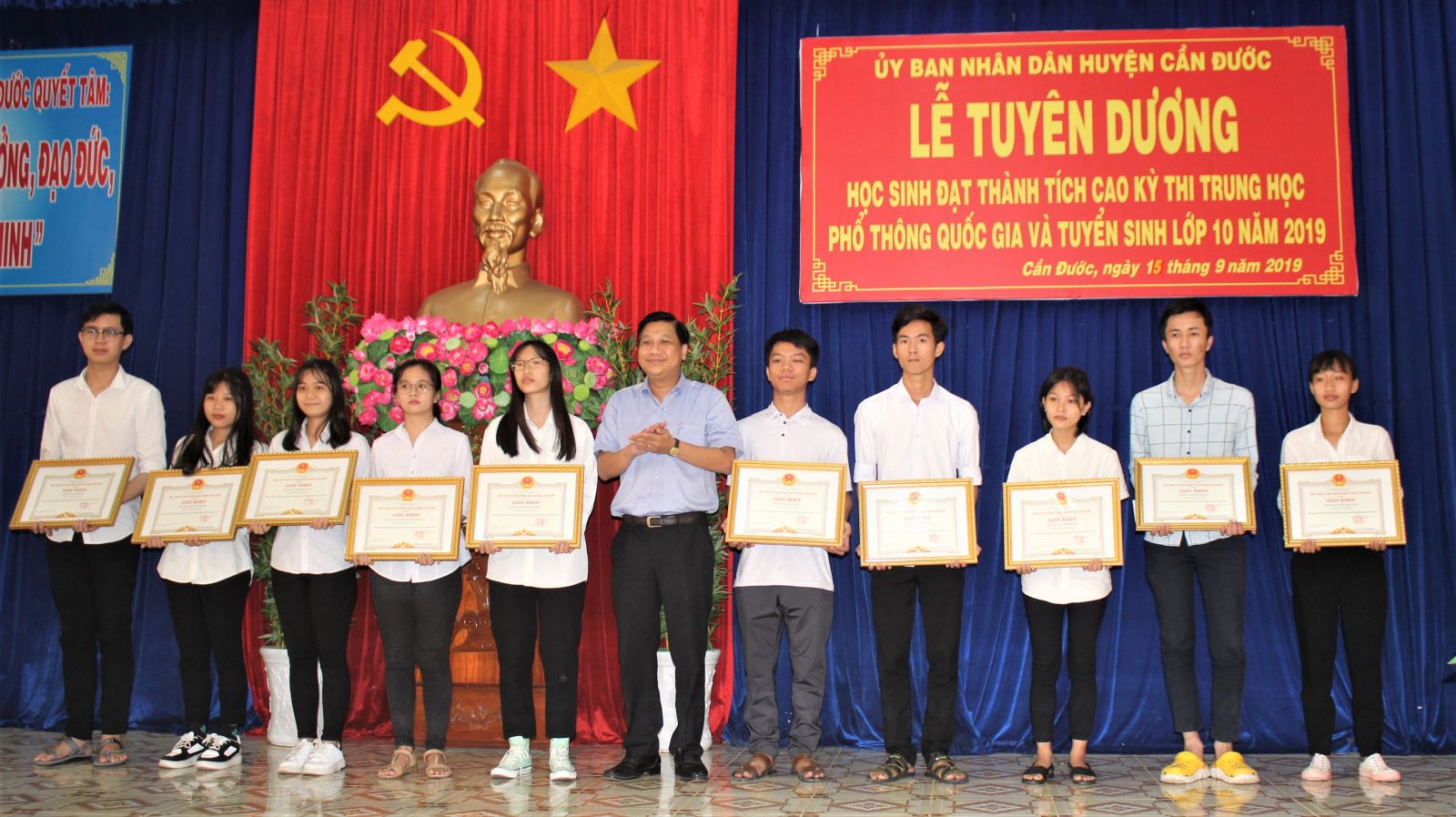 Secretary of Can Duoc district Party Committee - Nguyen Viet Cuong presents certificates of merit and bonuses to students