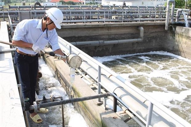 An expert checks wastewater at a wastewater treatment system in the Thang Long Industrial Zone in Hanoi's Dong Anh district (Photo: VNA)