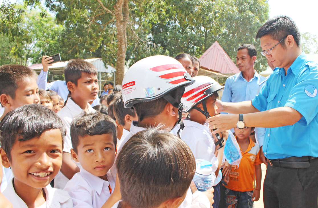 Chairman of the Vietnam Youth Union of Long An province - Vo Tran Tuan Thanh presents a helmet to poor households