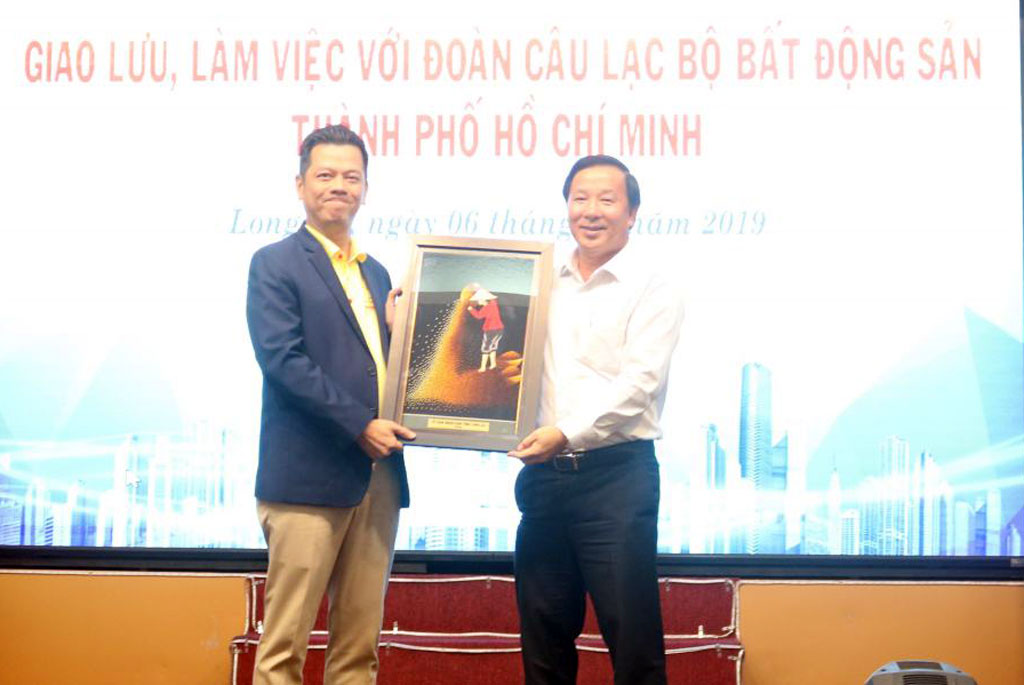 Vice Chairman of the Provincial People's Committee - Nguyen Van Ut (R) presents a souvenir to Ho Chi Minh City Real Estate Club