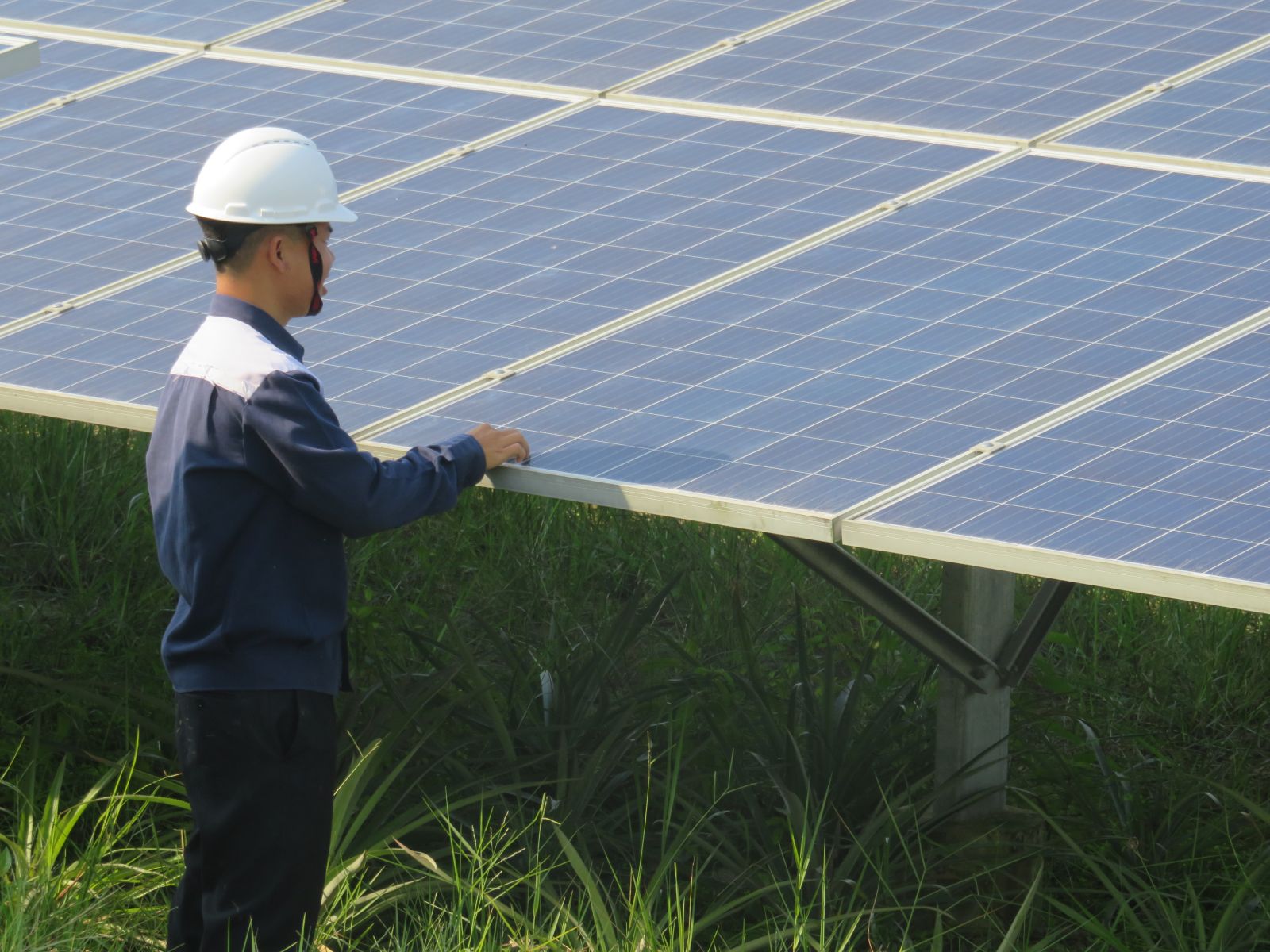 Workers check solar panels at Duc Hue  TTC Plant 1