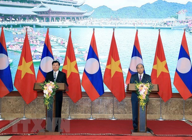 Prime Minister Nguyen Xuan Phuc (R) and his Lao counterpart Thongloun Sisoulith (Photo: VNA) 