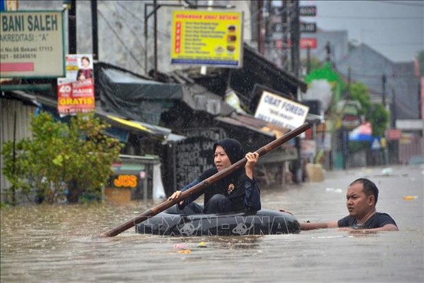 People take to paddling in small rubber lifeboats or tire inner-tubes to get around in Indonesia (Photo: AFP/VNA)