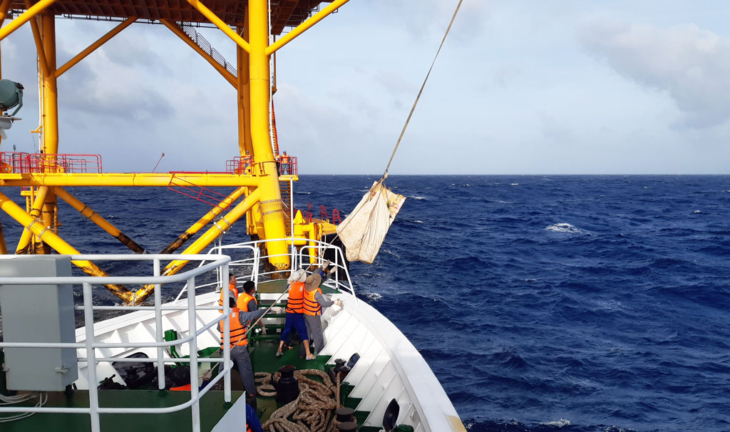 Due to high waves and strong winds, goods are transported to the rig by wire