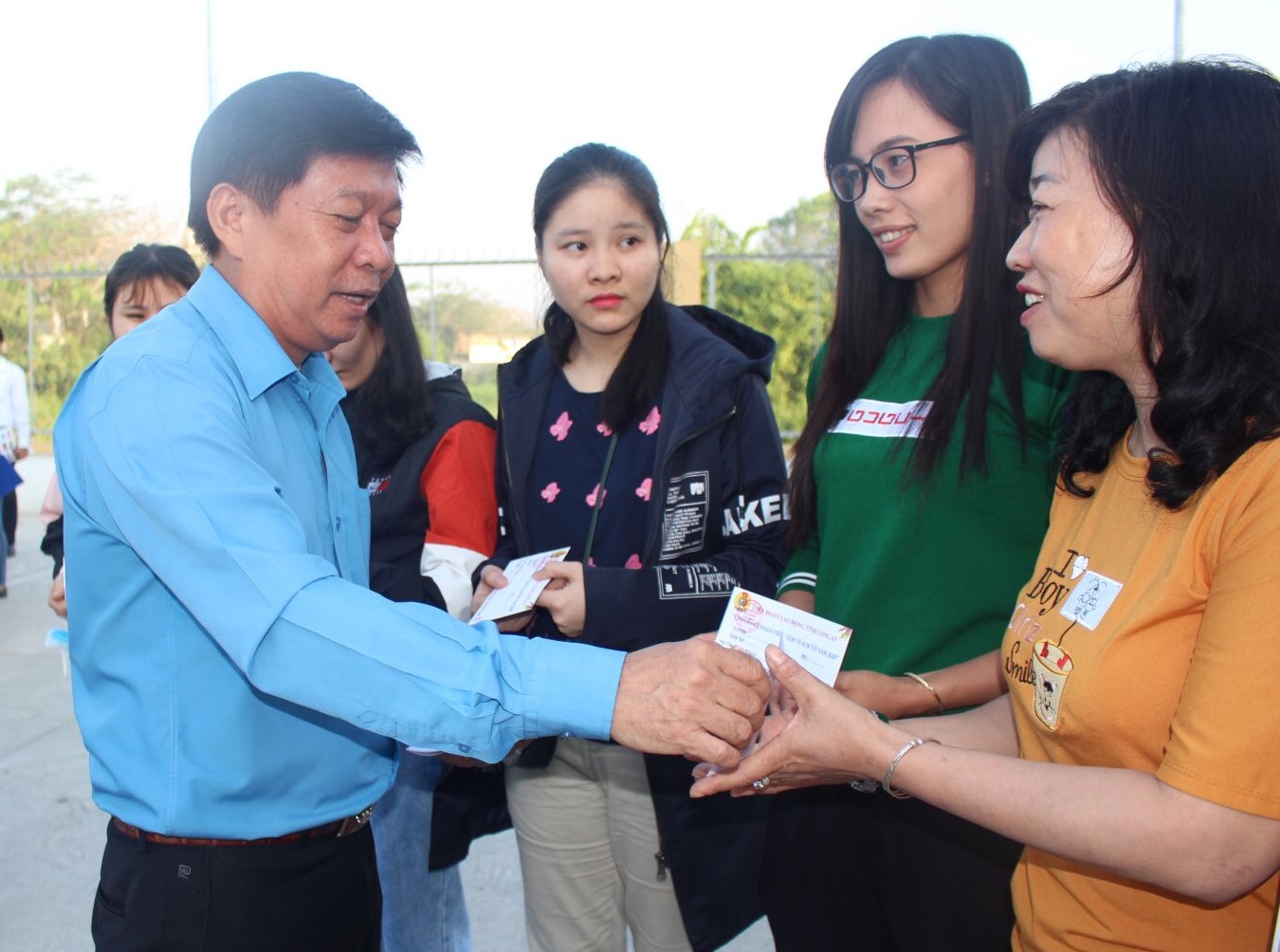 Chairman of Long An Labor Federation - Nguyen Van Qui presents bus tickets to workers and laborers 