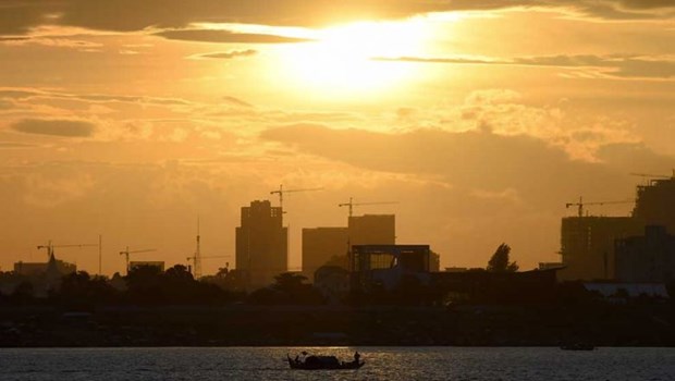 A boat travels along the Mekong river as high-rise buildings are seen in the distance in Phnom Penh, Cambodia (Photo: AFP)