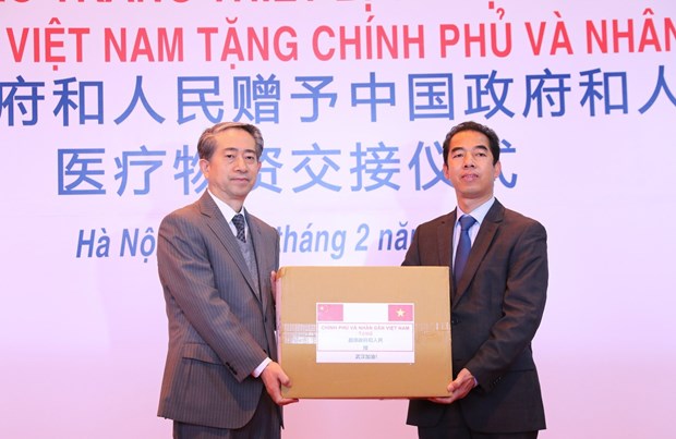 Deputy Minister of Foreign Affairs To Anh Dung (R) hands over the assistance to Chinese Ambassador Xiong Bo at the ceremony at Noi Bai International Airport in Hanoi on February 9 (Photo: VNA)