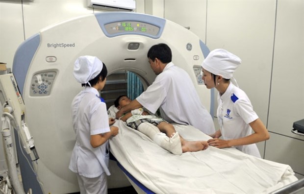 Doctors at Cho Ray Hospital in HCM City put a patient into a computerised tomography scanner. (Photo: VNA)