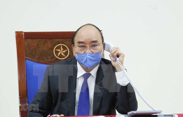 PM Nguyen Xuan Phuc talks on the phone with his Chinese counterpart (Photo: VNA) 