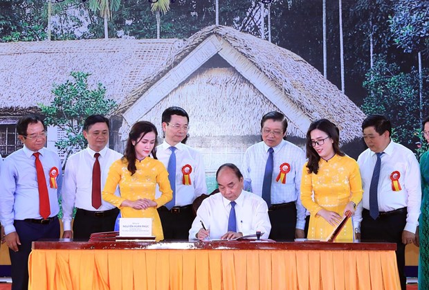 Prime Minister Nguyen Xuan Phuc signs the issuance of a special set of postage stamp on the occasion of the 130th birthday anniversary of President Ho Chi Minh. (Photo: VNA)