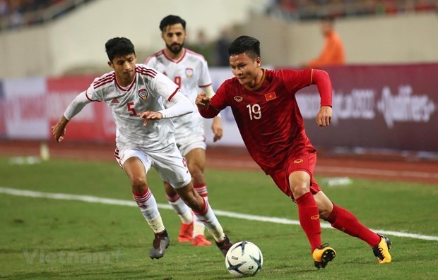 Vietnamese midfielder Nguyen Quang Hai (in red) vies for the ball in a match of the 2022 World Cup qualifiers (Photo: VNA)