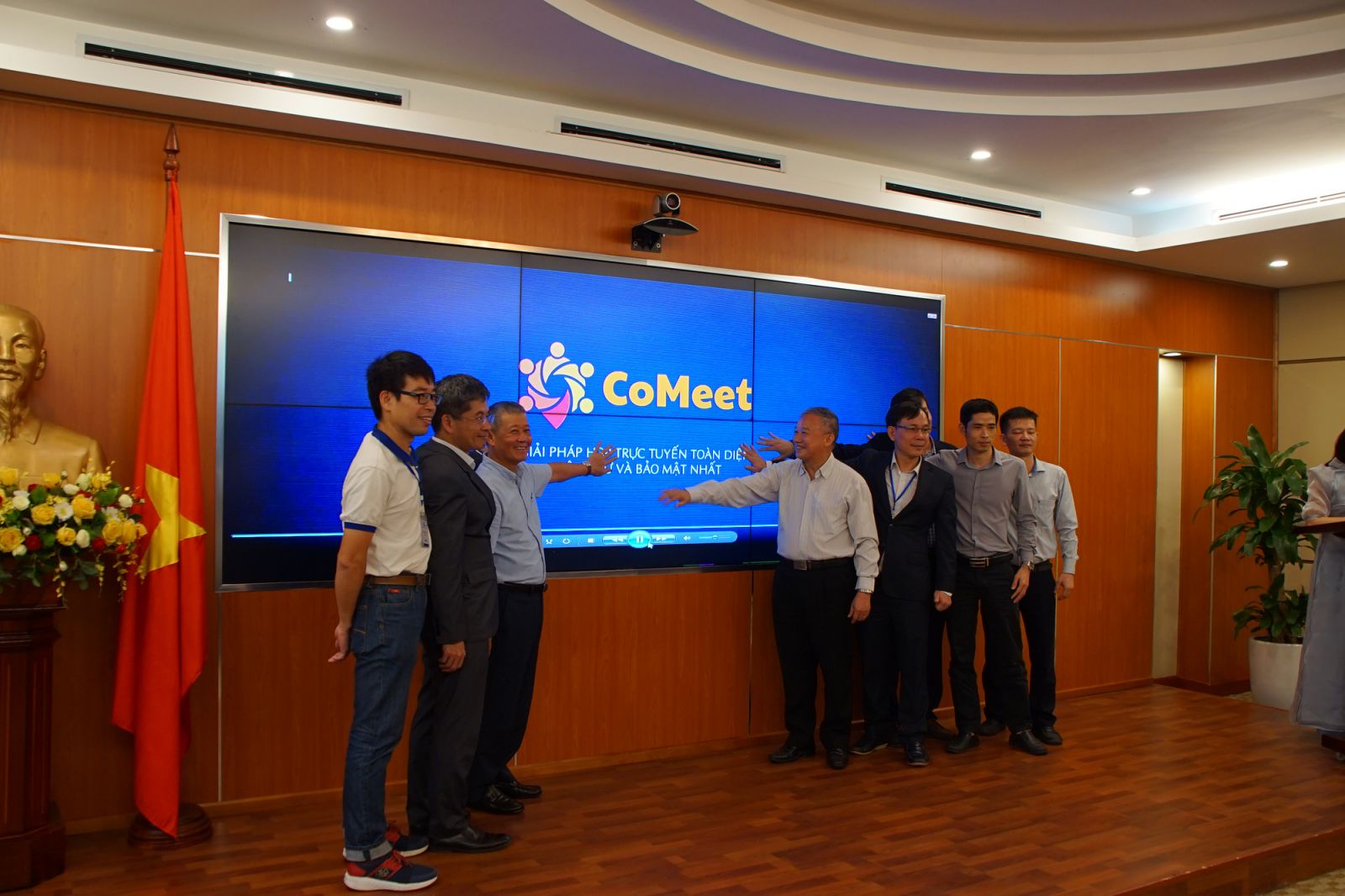 Representatives from members of the CoMeet Alliance pose for a photo against the backdrop of a screen showing the name of the virtual conference platform CoMeet at a launch ceremony in Hanoi, Vietnam, May 29, 2020. Photo: Thanh Ha / Tuoi Tre