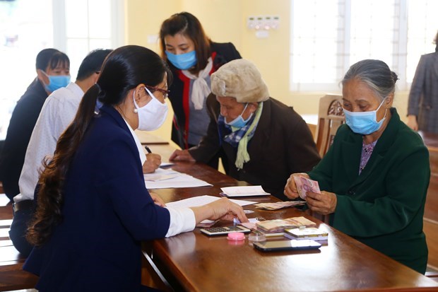 People facing difficulties caused by the COVID-19 pandemic receive financial aid in Ha Nam province (Photo: VNA)