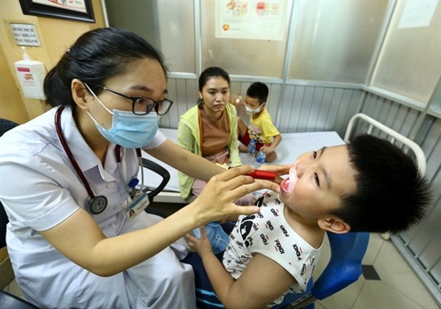 A doctor treats a boy at the Vietnam-Cuba Hospital's Paediatrics Department. (Photo: VNA)