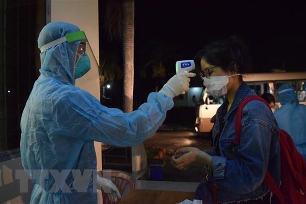 Checking temperature for a Vietnamese citizen returning home from abroad (Illustrative photo: VNA)