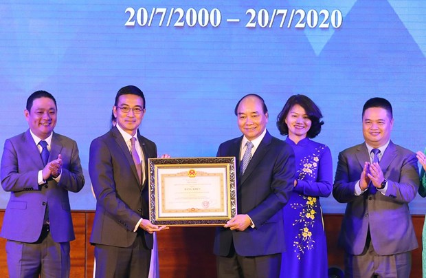 Prime Minister Nguyen Xuan Phuc (third, right) presents a merit certificate to the Ho Chi Minh Stock Exchange at the ceremony on July 20 (Photo: VNA)