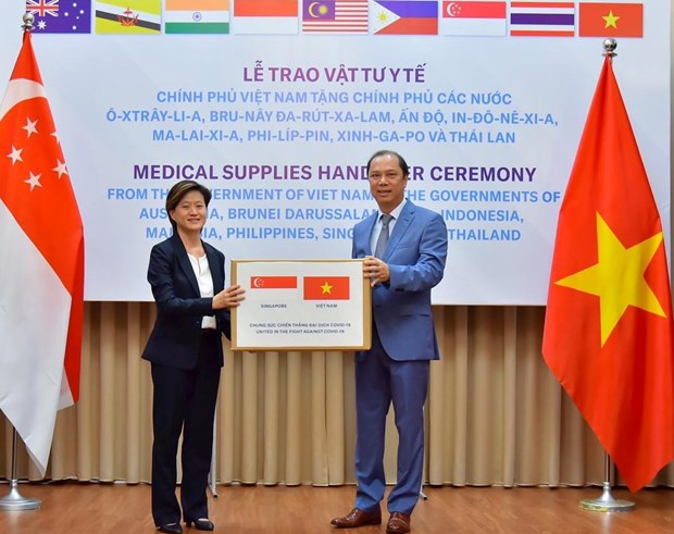 Singaporean Ambassador Catherine Wong Siow Ping (left) receives a donation of Reverse Transcription Polymerase Chain Reaction test kits from Vietnamese Deputy Foreign Minister Nguyen Quoc Dung in May (Photo courtesy of the Singaporean Embassy)