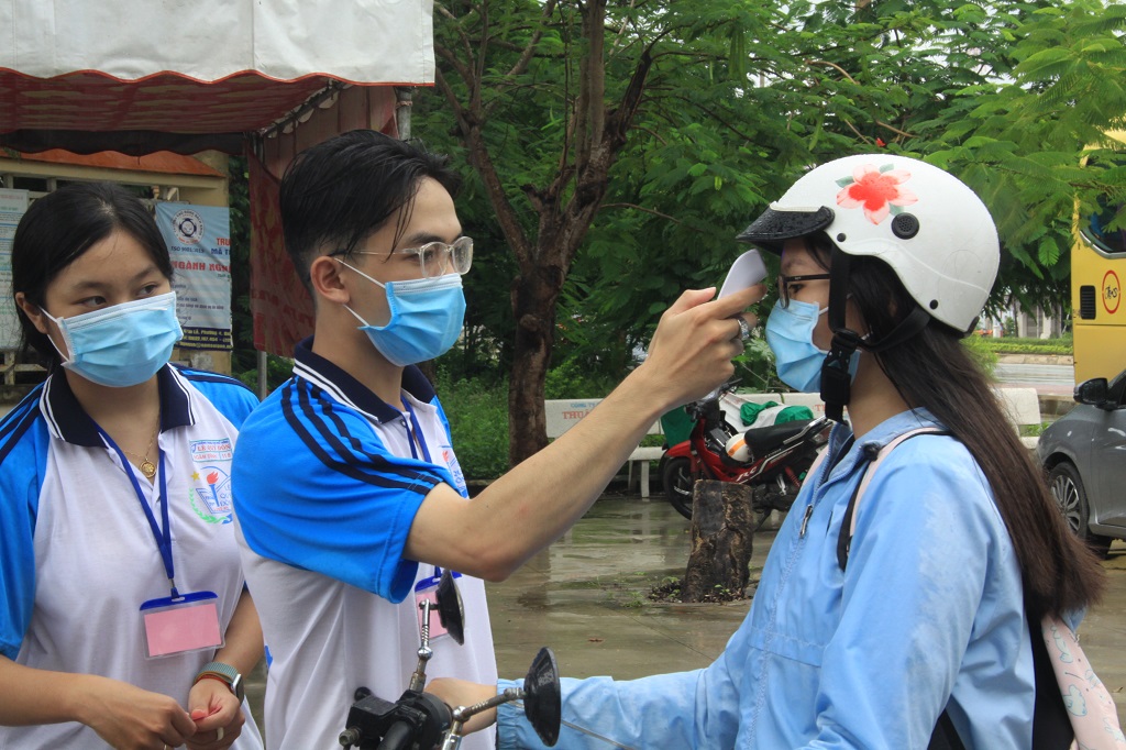 Candidates are measured body temperature before entering the test site