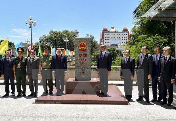 Deputy PM and FM Pham Binh Minh (left) and Chinese State Counsellor and FM Wang Yi visit border landmark 1369 in China. (Photo: VNA)