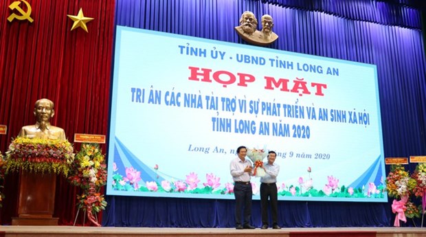 Former State President Truong Tan Sang (R) at the ceremony to honour donors who made contributions to social security development in Long An (Photo: https://thanhnien.vn/)