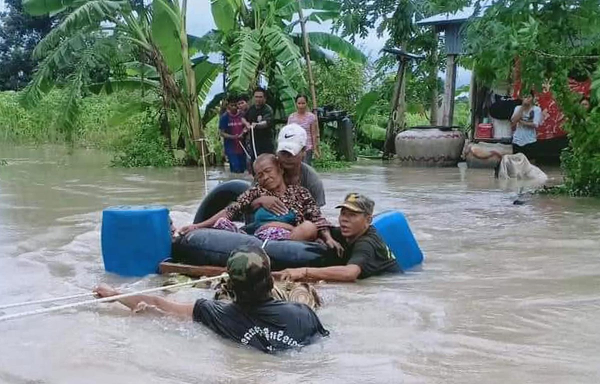 Các binh sỹ hỗ trợ người dân sơ tán khỏi vùng lũ tại tỉnh Battambang, Campuchia. (Ảnh: AFP/TTXVN)