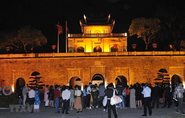 Visitors stand in front of Doan Mon (Main Gate) of the Thang Long Imperial Citadel in the evening (Photo: VNA)