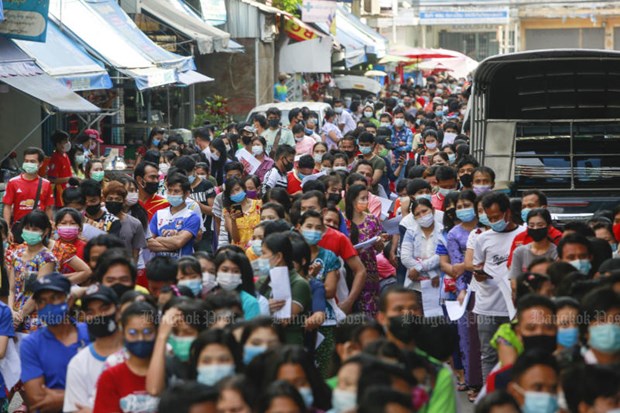 Myanmar labourers wait for their turn to be tested for COVID-19 in Muang district of Samut Sakhon (Photo: Bangkok Post)