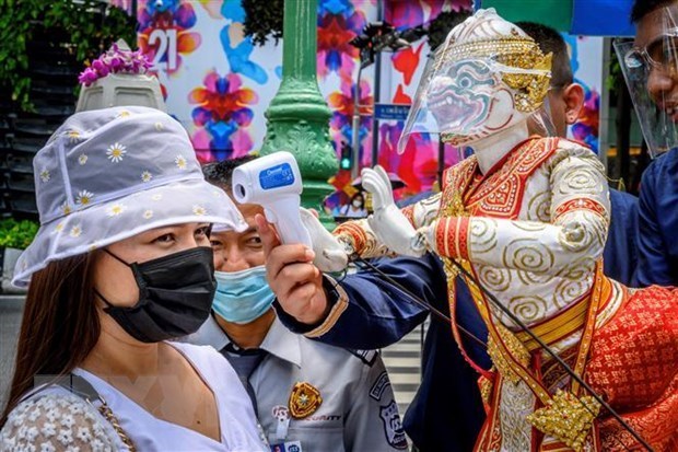 A tourist has her body temperature checked at a temple in Bangkok, Thailand (Photo: AFP/VNA)