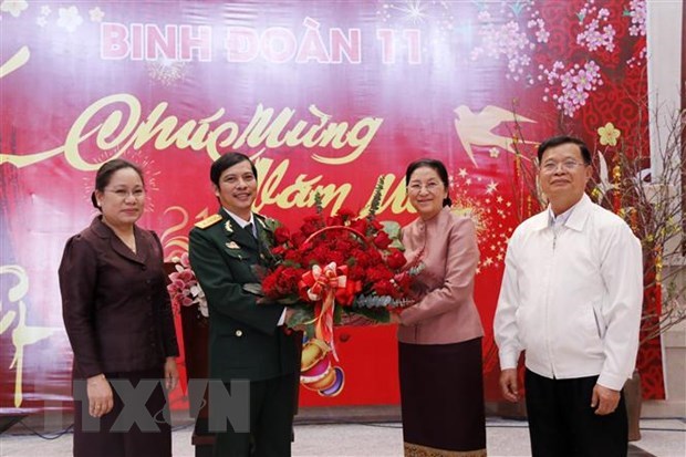 Lao NA Chairwoman Pany Yathotou presents a basket of flowers to Deputy Commander of Army Corps 11 Col. Nguyen Chien to welcome the Year of the Buffalo (Photo: VNA)