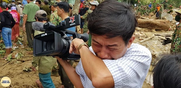 A Vietnam News Agency reporter bursts into tears when the body of a baby was retrieved from a landslide in Tra Leng commune of central Quang Nam province (Photo: VNA)