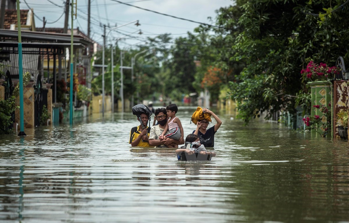 Residents evacuate their flooded homes in Gresik, East Java, Indonesia on December 15, 2020, as the rainy season brings floods to many areas in Jakarta and Java. (Photo: AFP/VNA)