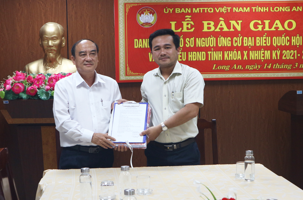 Chairman of the Vietnam Fatherland Front Committee of the province - Truong Van No (L) receives the list and dossiers of candidates for the National Assembly and Provincial People's Council for term 2021-2026