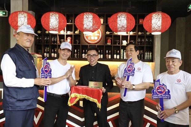 (From left) WHO Representative in Vietnam Kidong Park (left), Vietnamese actor Xuan Bac (second from left), owner of Cantonese restaurant San Fu Lou in Hoan Kiem district, along with Luong Ngoc Khue, head of the Health Ministry's Department of Medical Examination and Treatment and Director of the Vietnam Tobacco Control Fund, participate in placing no smoking signs at the restaurant. (Photo: VNA)