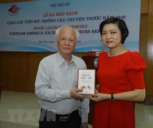 Nguyen Van Huynh (L) presents his book, titled "Vietnam-America  exchanges: Stories before 1946" to a guest at the book launch (Photo: VNA)