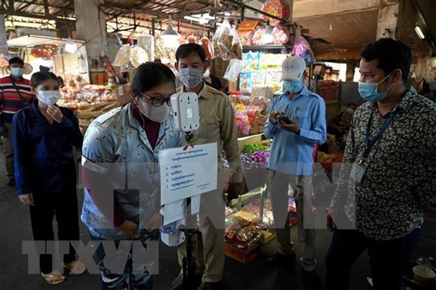 Checking people's body temperature at a market in Phnom Penh (Photo: AFP/VNA)