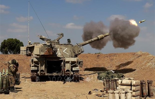 Israeli troops fire towards the Gaza Strip from their post in Sderot city of Israel (Photo: AFP/VNA)