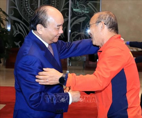 President Nguyen Xuan Phuc (L) shakes hands with the national football team's head coach Park Hang-seo (Photo: VNA)