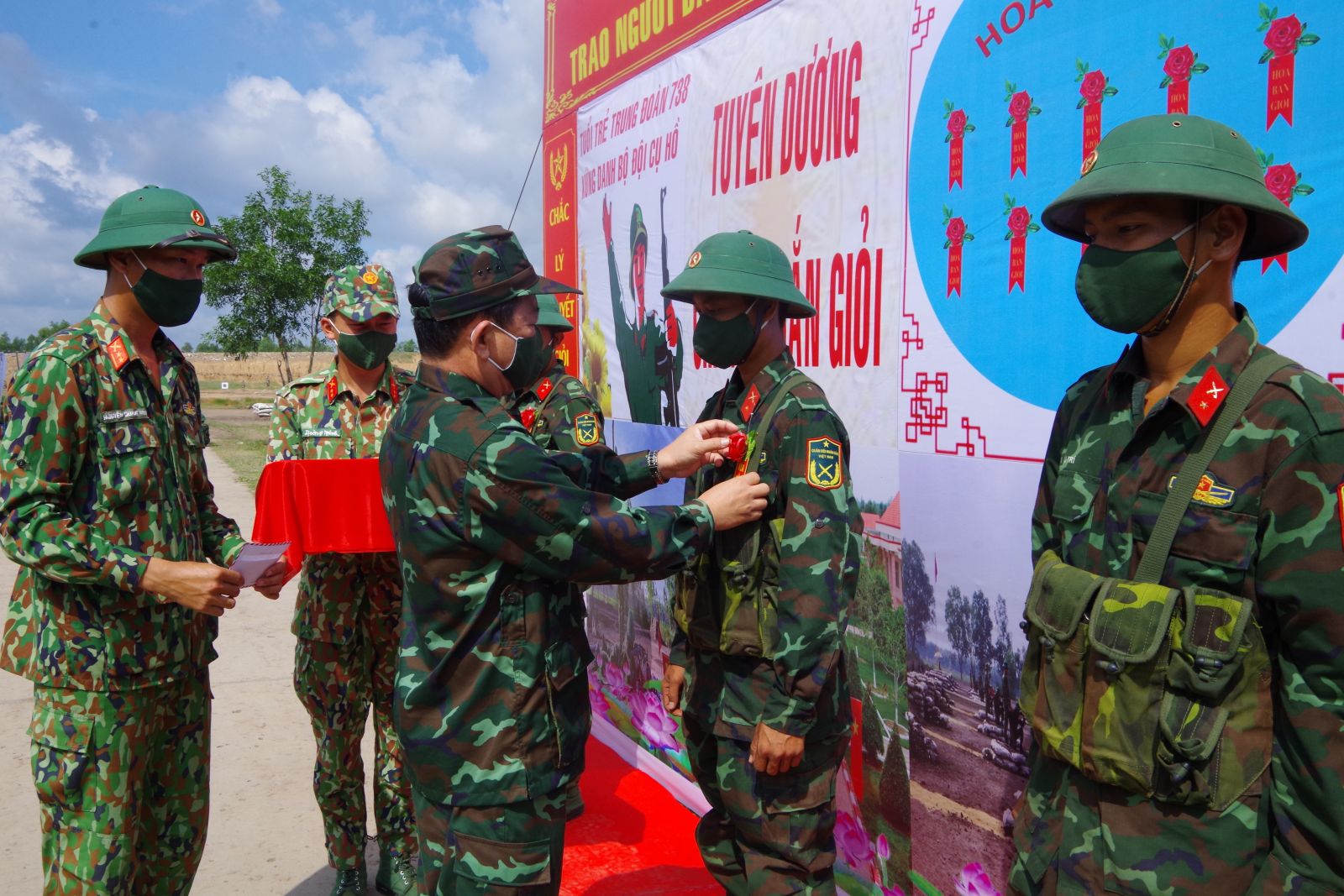 Đại tá Trần Đình Hưng - Phó Chỉ huy trưởng kiêm Tham mưu trưởng Bộ Chỉ huy Quân sự tỉnh, tặng hoa hồng bắn giỏi cho những xạ thủ đạt thành tích xuất sắc