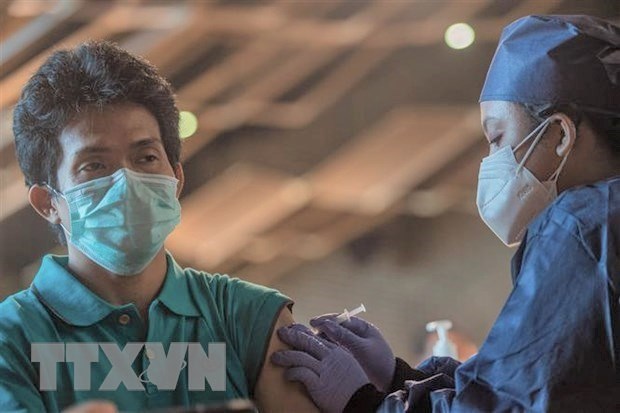  A health worker administers a shot of COVID-19 vaccine to a local resident in Jakarta, Indonesia on July 23. (Photo: XINHUA/VNA)