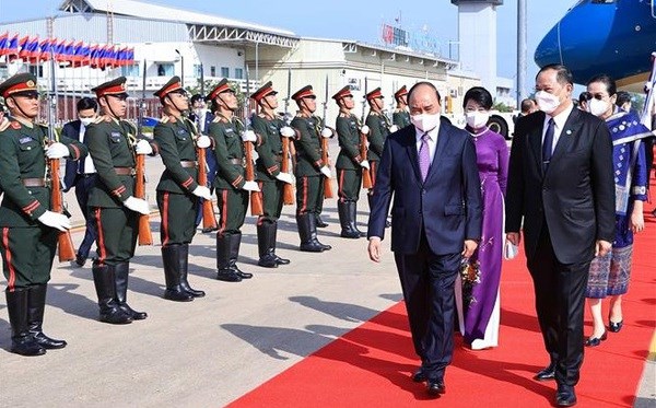 President Nguyen Xuan Phuc and the Vietnamese delegation are welcomed at the Wattay International Airport (Photo: VNA)