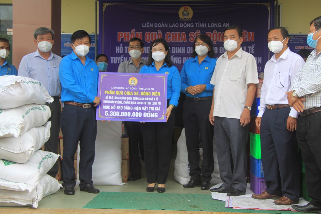 Chairman of the Provincial Labor Confederation - Nguyen Van Qui presents the symbolic board of the gift to share and encourage the medical staff to the Chairman of the Provincial Health Trade Union