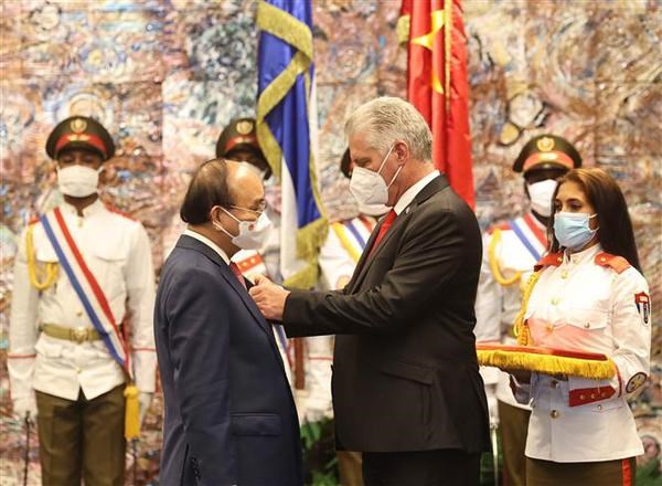 On behalf of the Party, State and people of Cuba, President Miguel Diaz Canel presents the Vietnamese State leader with José Marti Order, the noblest reward of the Cuban State (Photo: VNA)